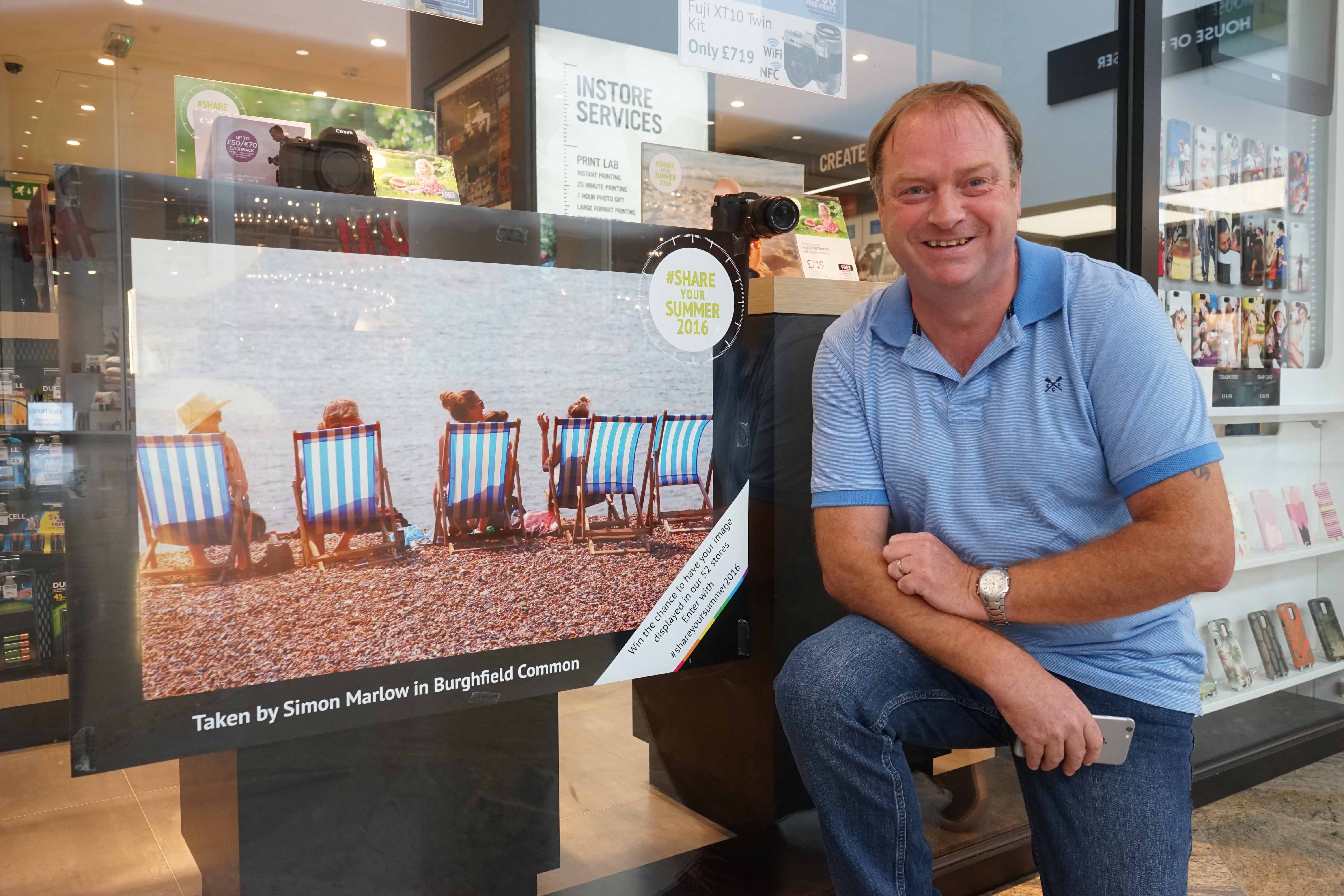 Simon Marlow next to his winning image displayed in Jessops Reading